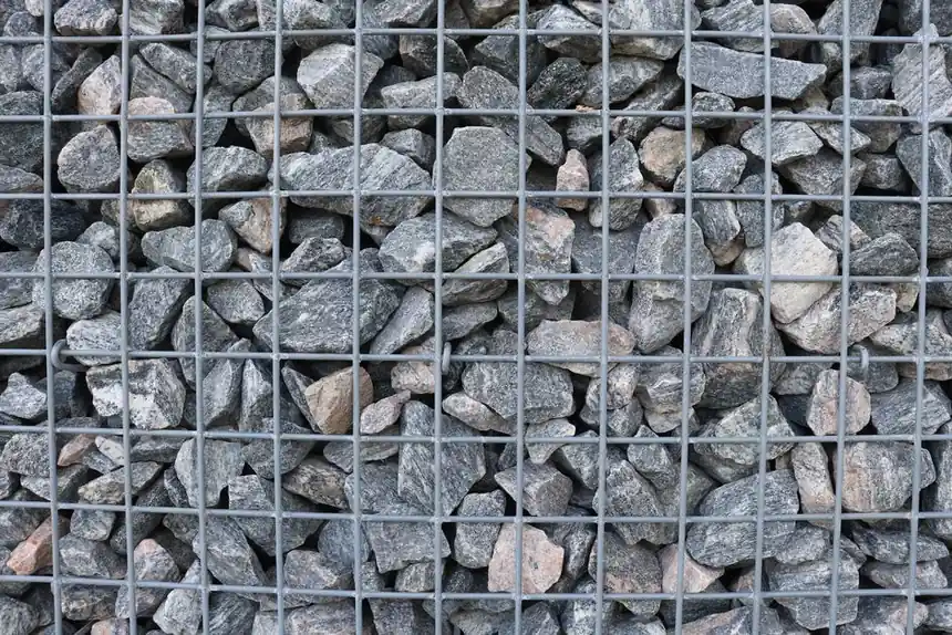Detailed view of a gabion wall filled with natural stones arranged tightly.