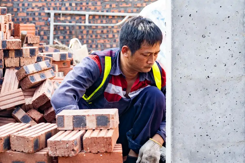 Focused worker laying bricks at construction site in Hải Phòng.